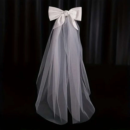 Ivory satin bridal bow veil headdress with a delicate tulle veil, perfect for weddings and special occasions. Lightweight and elegant wedding hair accessory