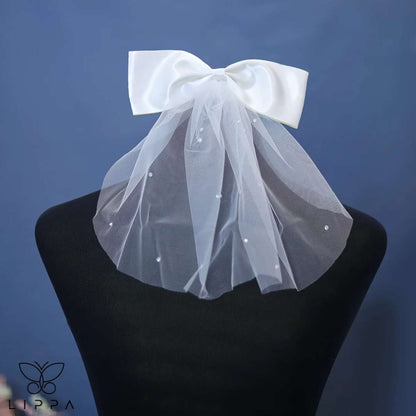 Ivory satin bridal bow veil headdress with a delicate tulle veil, perfect for weddings and special occasions. Lightweight and elegant wedding hair accessory