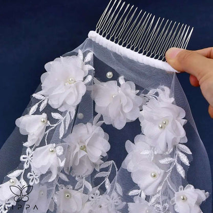 Close-up of lace appliques and pearl beading on wedding veil.