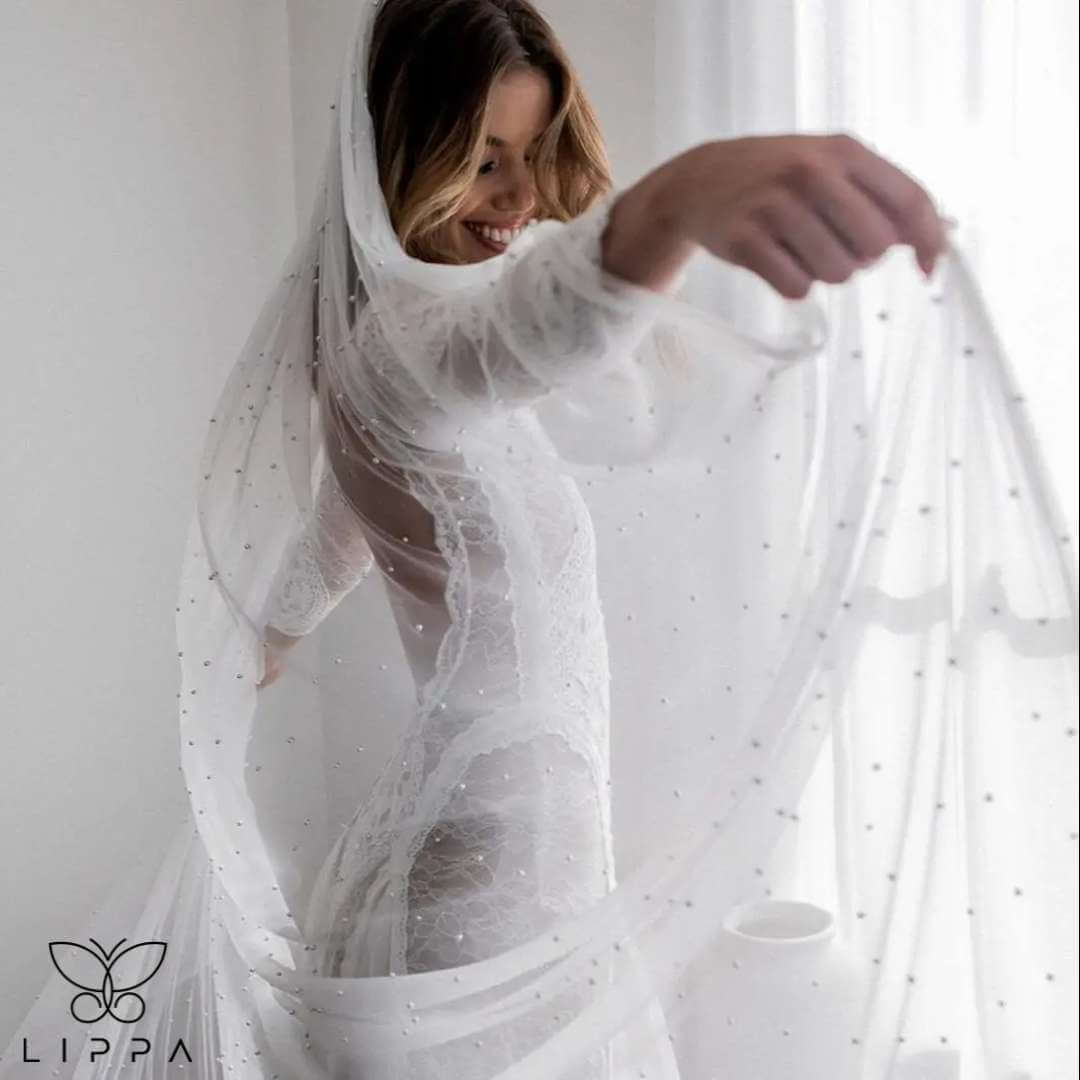 Elegant cathedral-length bridal veil made of soft tulle with delicate pearl embellishments, featuring a 1-tier design and attached comb for secure wear. Perfect wedding accessory