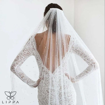 Elegant cathedral-length bridal veil made of soft tulle with delicate pearl embellishments, featuring a 1-tier design and attached comb for secure wear. Perfect wedding accessory